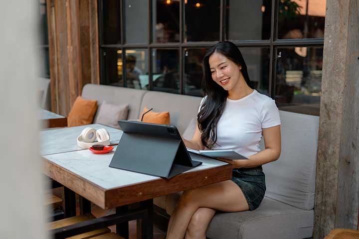Young Filipina Freelancer Working Remotely From a Cafe