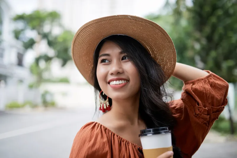 Woman relaxing outdoors with coffee, capturing contentment and genuine presence in daily moments