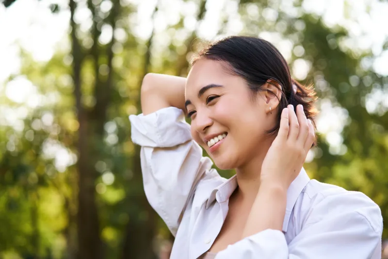 Happy Filipina outdoors in casual elegance, symbolizing respect and joy in pre-wedding traditions