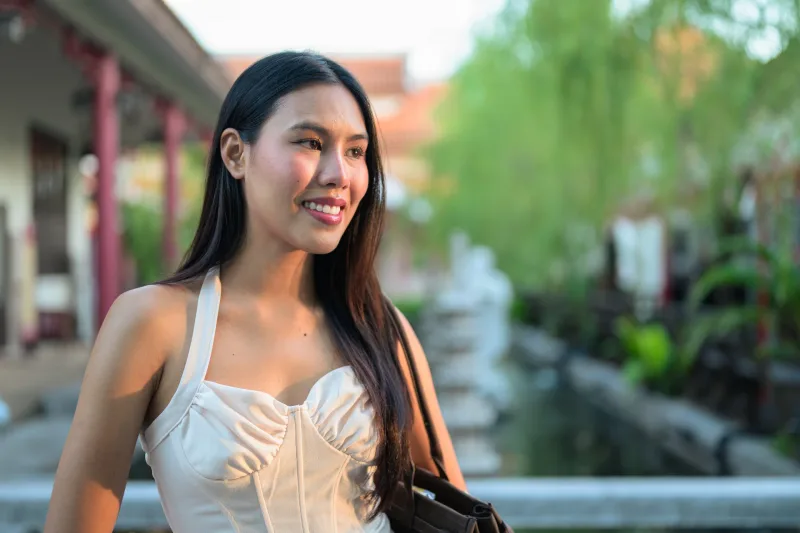 Filipina woman in tropical garden setting, smiling in natural environment
