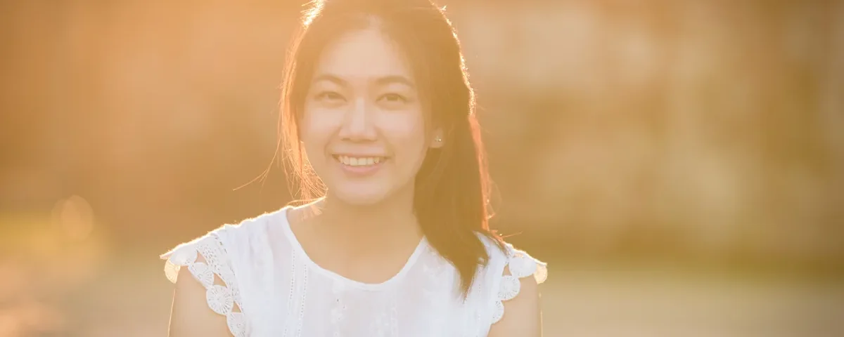 Smiling woman in golden-hour light embodying authentic confidence for genuine online relationship building