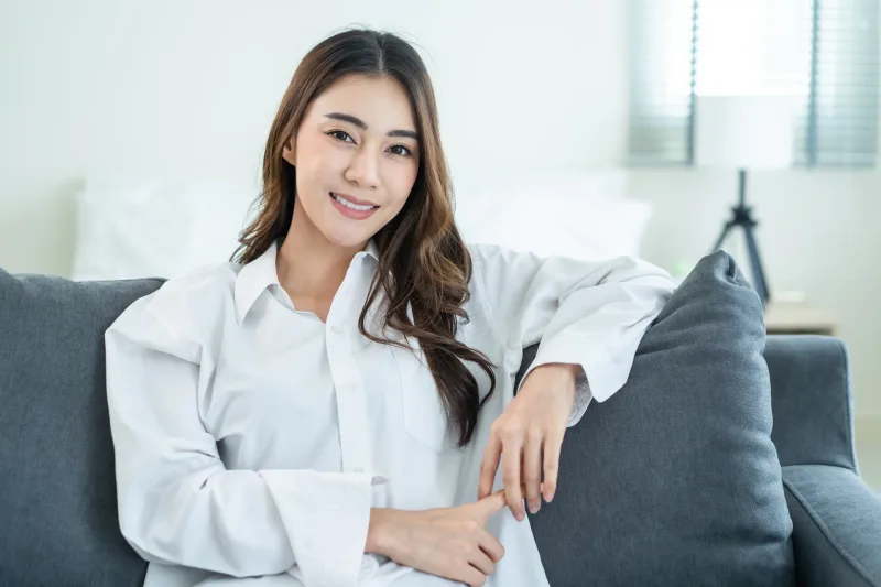 Filipina woman smiling warmly while relaxing, expressing approachable confidence