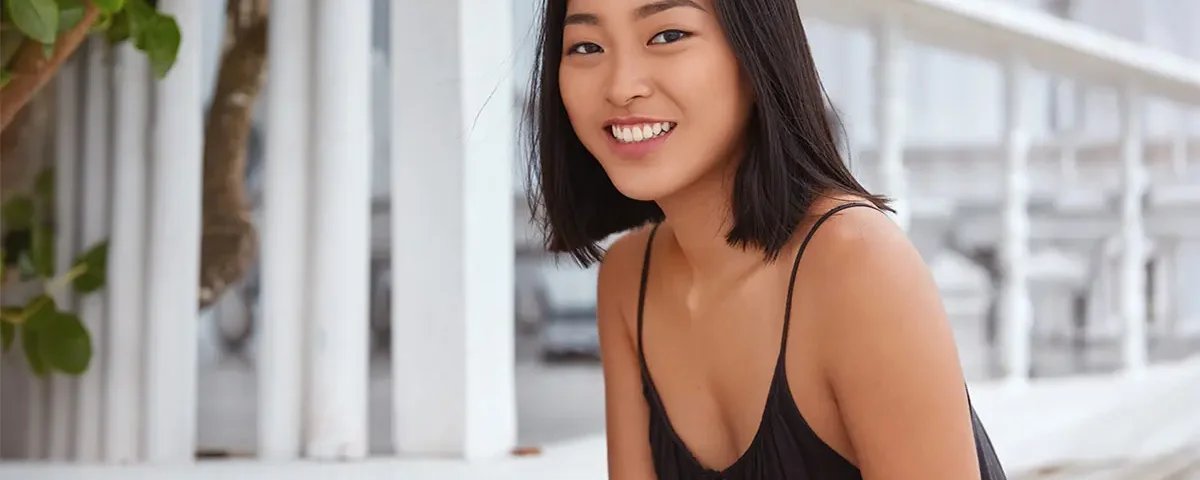 Filipina woman smiling indoors in relaxed lifestyle portrait for dating profile