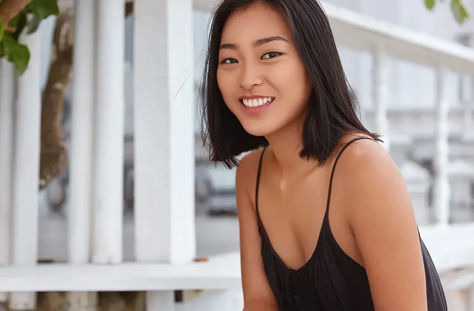 Filipina woman smiling indoors in relaxed lifestyle portrait for dating profile