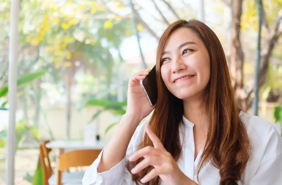 Filipina woman chatting happily on her mobile phone