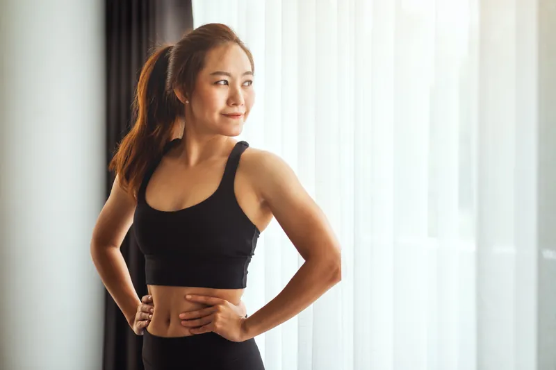 Woman in fitness attire with composed expression indoors