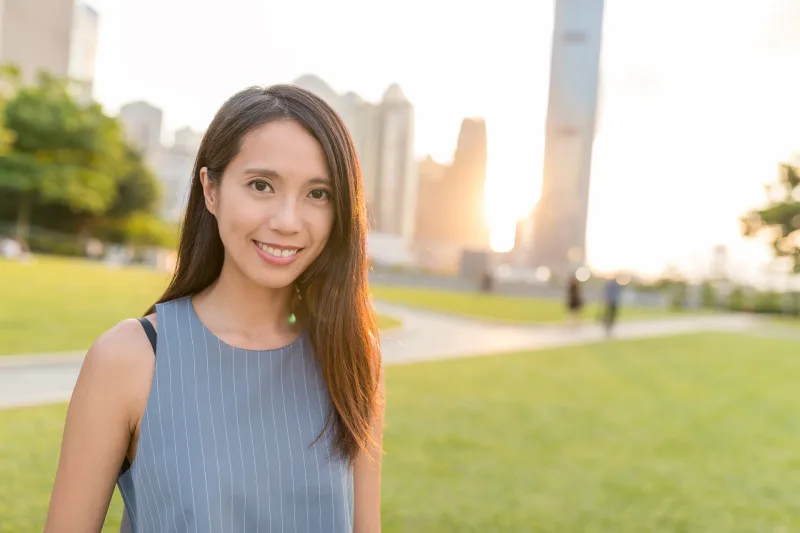Professional woman against urban skyline at sunset with confident posture