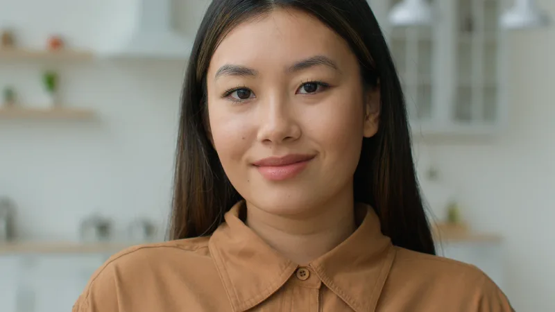 Close-up portrait of a Filipina with genuine smile, expressing the warmth she extends to those she respects.