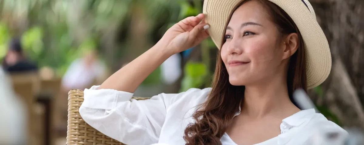 Filipina woman in white shirt smiling genuinely in tropical park setting