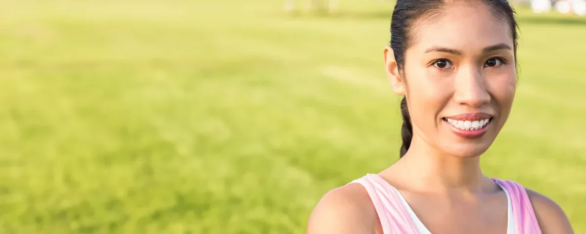 Smiling young woman in casual shirt outdoors with cheerful expression