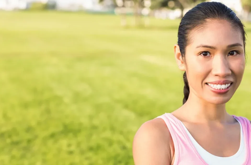 Smiling young woman in casual shirt outdoors with cheerful expression
