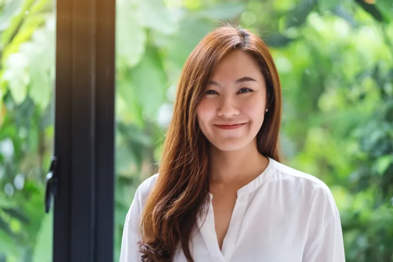 Gentle portrait of Asian woman with natural outdoor lighting and peaceful expression