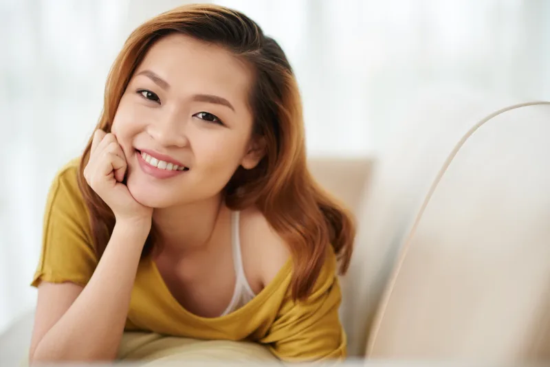 Cheerful woman in relaxed home setting, representing the approachable nature of women in Davao's community spaces