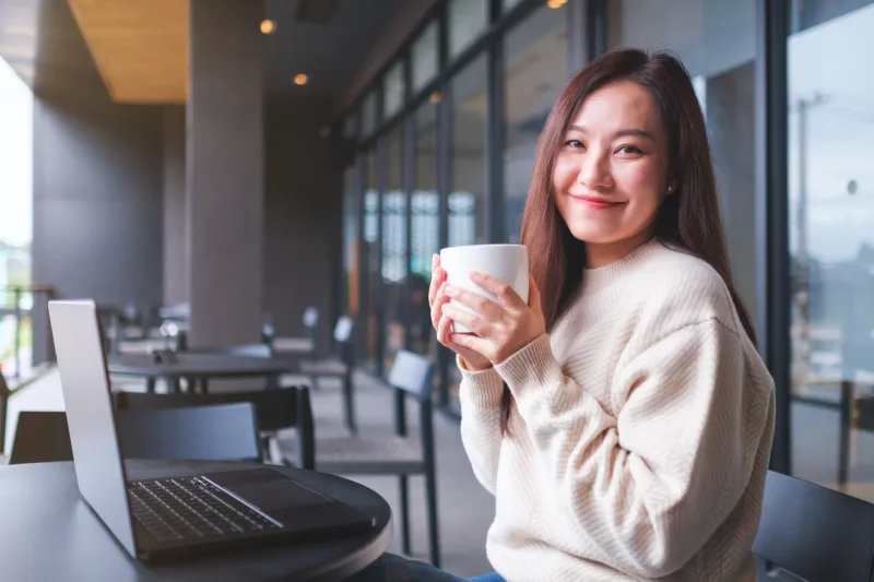 Woman enjoying coffee break in modern office workspace