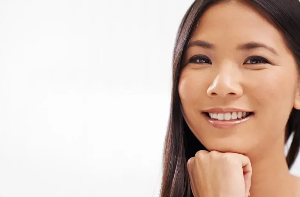 Woman with confident expression and warm smile, embodying the approachable authenticity that strengthens serious relationships.