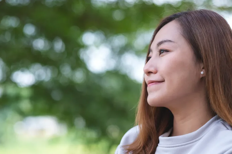 Woman in nature with thoughtful, peaceful expression