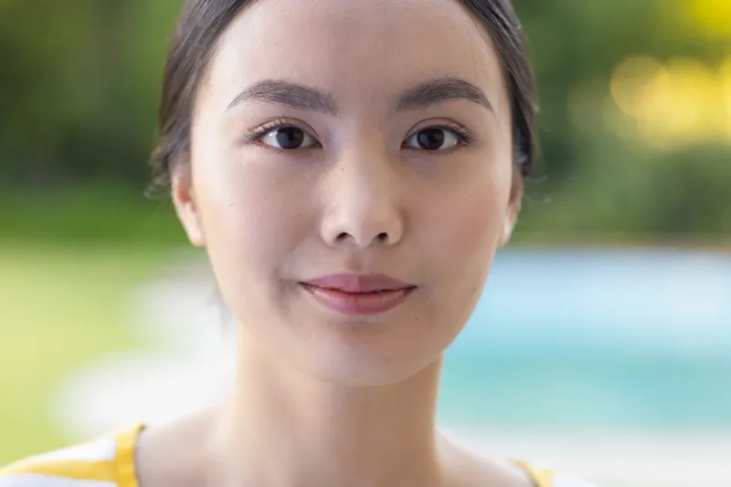 Woman with gentle smile in outdoor natural light