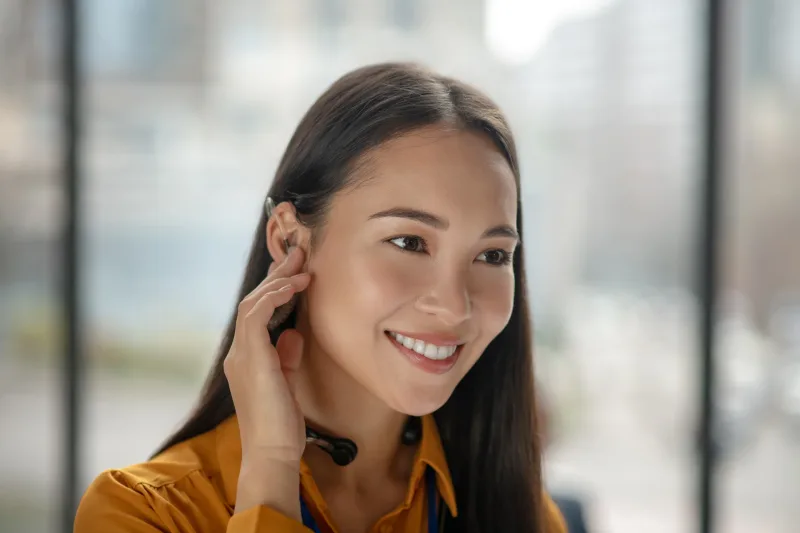 Professional woman wearing headset in office environment, depicting career context for meaningful conversation starters