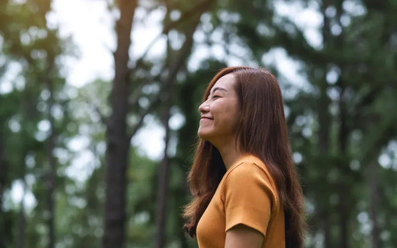 Young woman smiling outdoors with peaceful contemplative mood