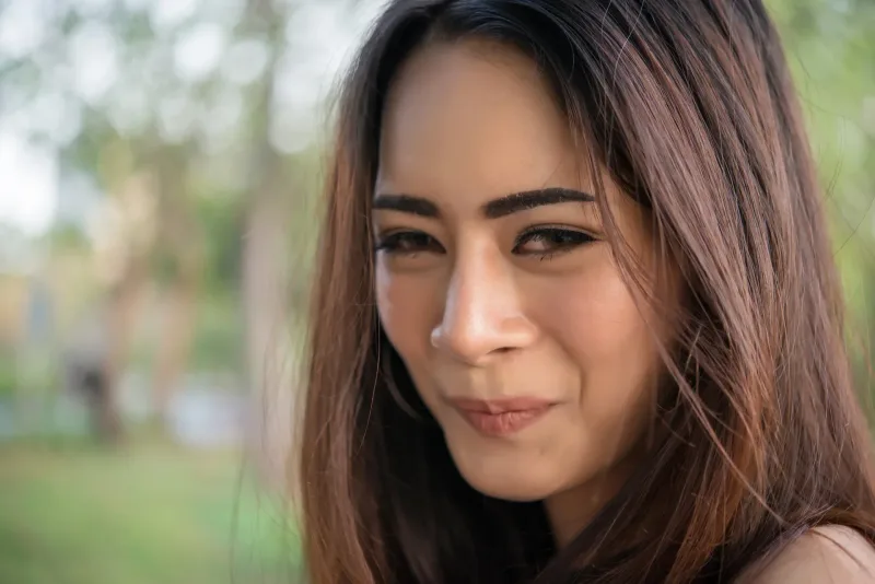 Woman relaxing peacefully in nature park with serene expression