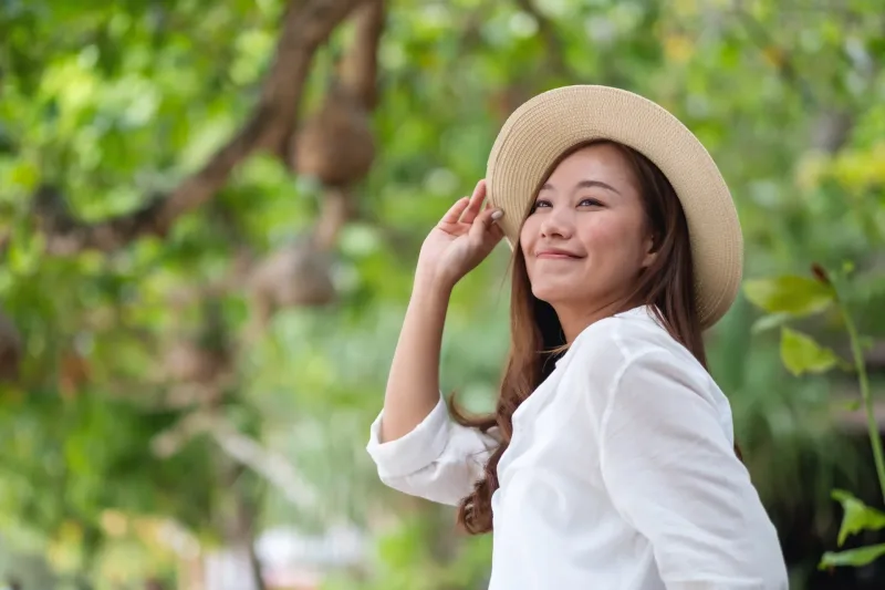 Young Asian woman with serene expression in natural setting