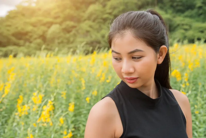 Young woman in golden hour light with peaceful, composed expression in nature