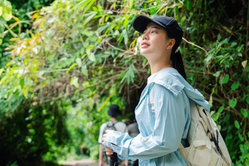 Woman on forest trail exploring nature independently, symbolizing authentic cross-cultural connection