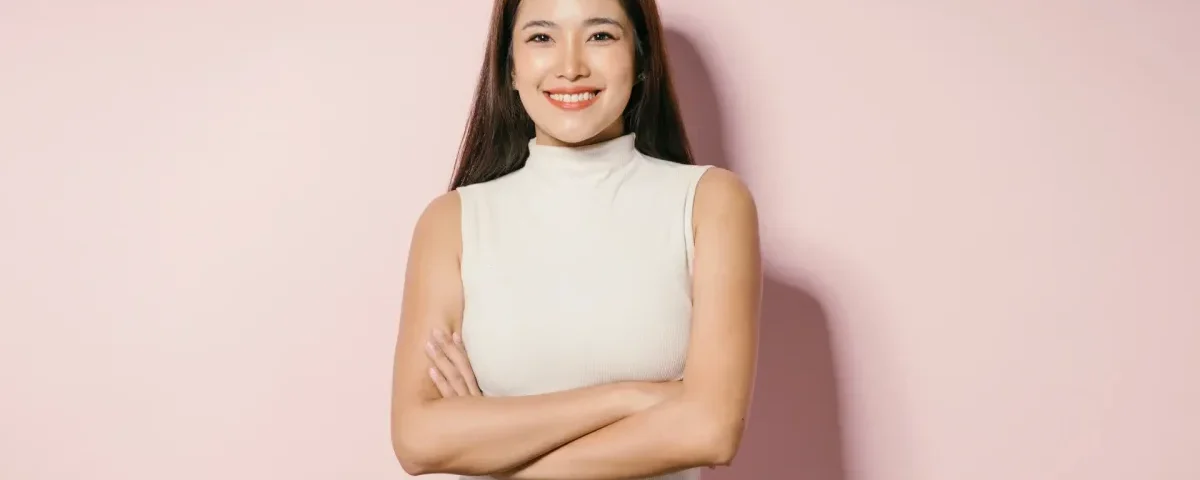 Woman in sleeveless top with confident smile and crossed arms