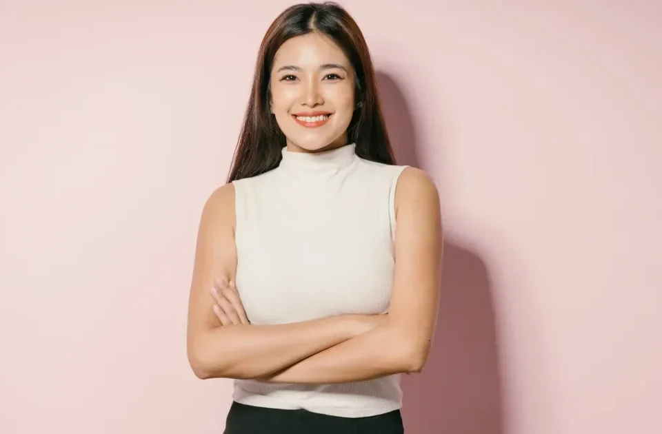 Woman in sleeveless top with confident smile and crossed arms