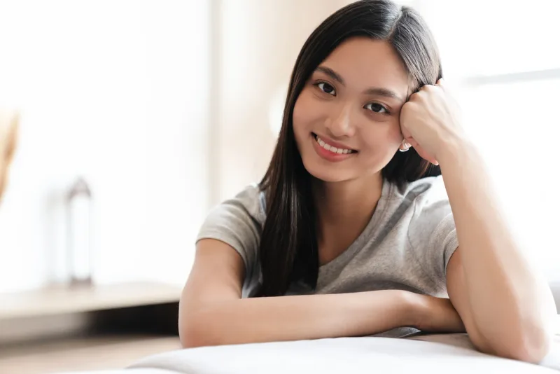 Woman relaxing at home with warm, genuine smile