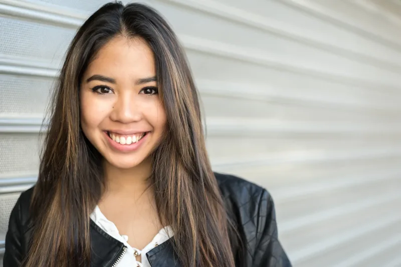 Woman smiling confidently in front of metal background