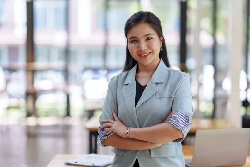 Woman in office setting with confident, professional demeanor