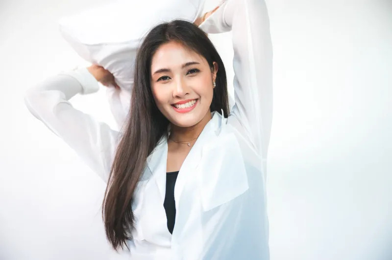 Woman in professional white blazer, confident pose indoors