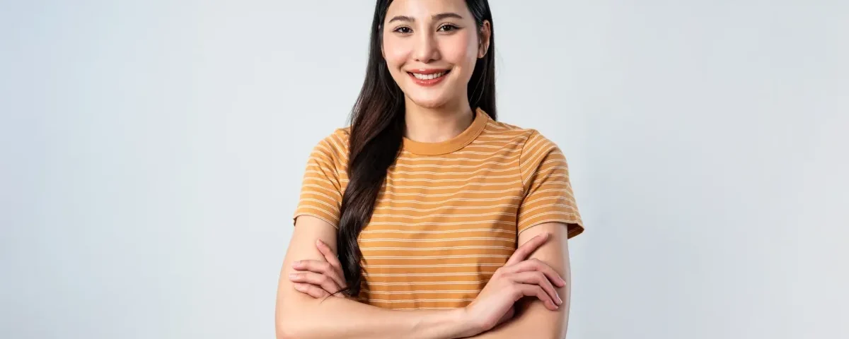 Confident young woman smiling indoors with relaxed, welcoming posture