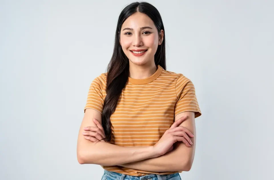 Confident young woman smiling indoors with relaxed, welcoming posture