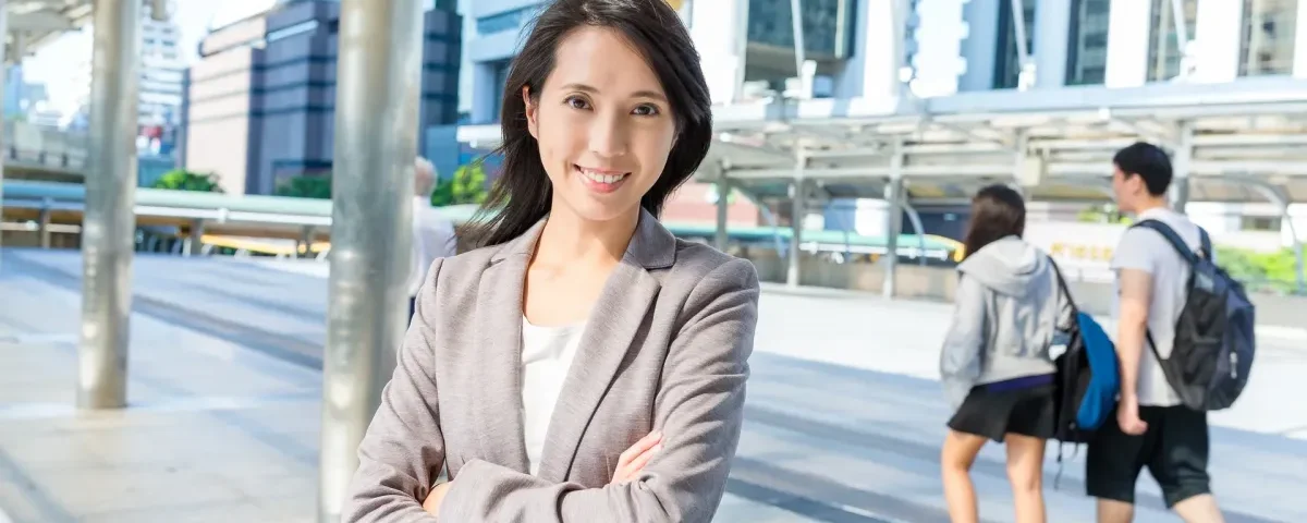 Woman smiling confidently in urban setting, embodying poise during engagement preparation