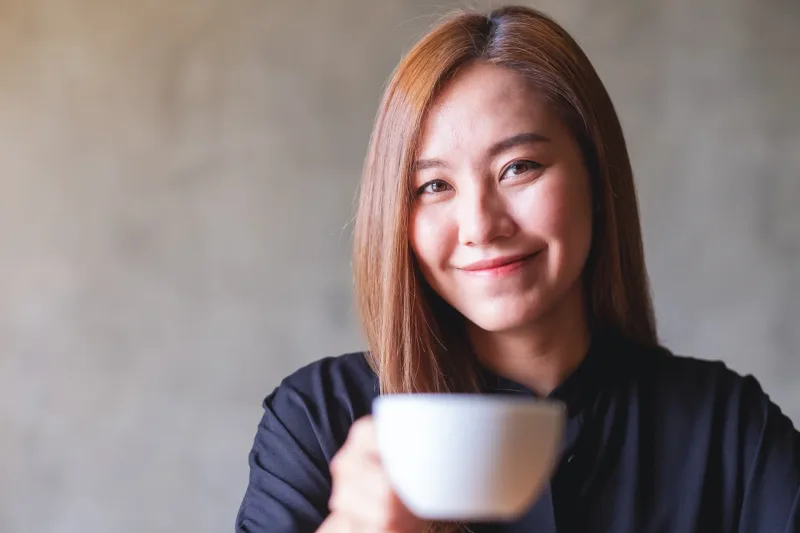 Woman holding cup of coffee, relaxed and contemplative portrait