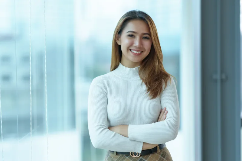 Professional woman in business attire smiling confidently in modern office