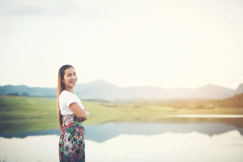Woman smiling peacefully in natural park setting, representing genuine connection