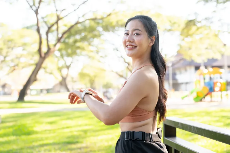 Active woman smiling outdoors, expressing thoughtful attention and care