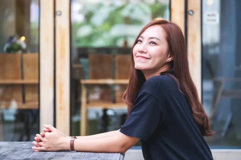 Woman with warm smile in relaxed social setting demonstrating ease