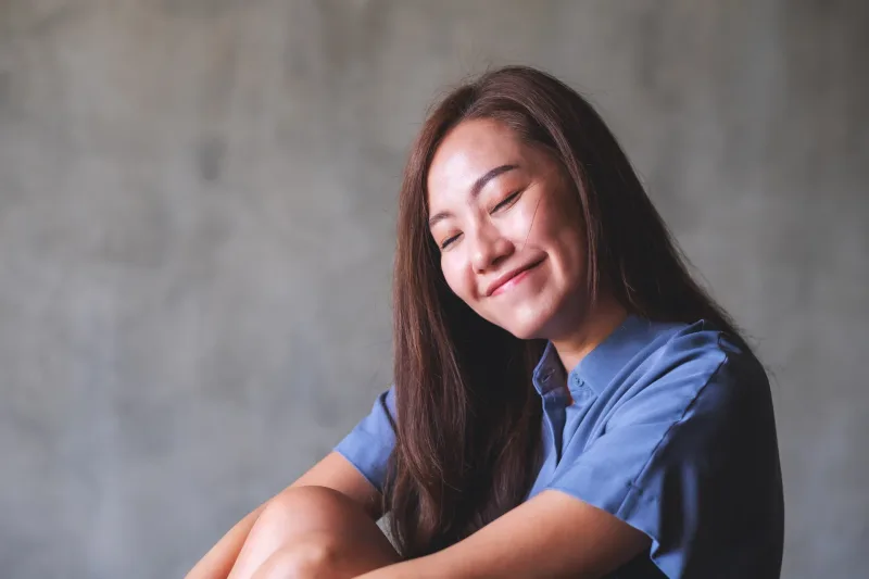 Woman displaying contentment and genuine laughter with relaxed expression