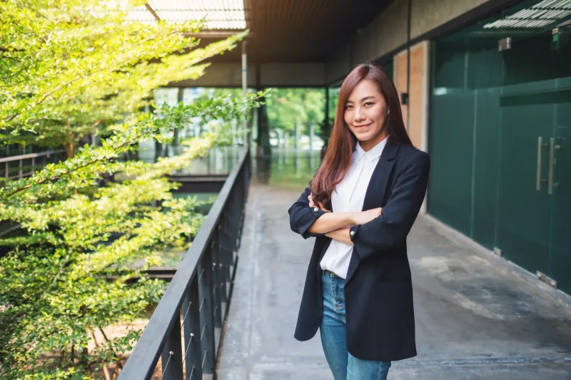 Asian woman with confident expression in modern architectural setting, professional presence