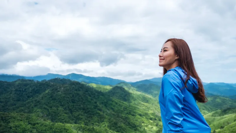 Woman traveler gazing at mountain landscape, representing contemplative presence
