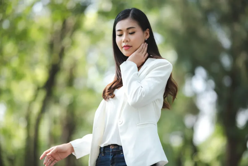 Woman in white blazer posing in outdoor setting