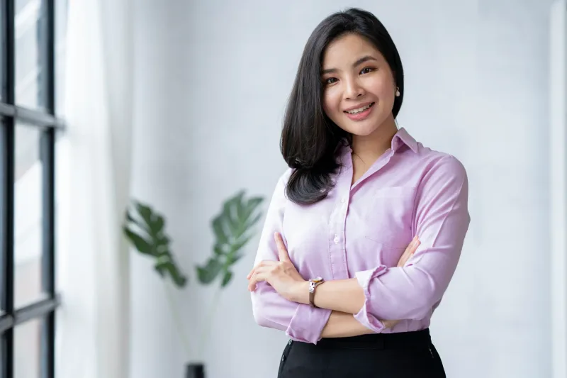 Professional woman in pink shirt smiling in office