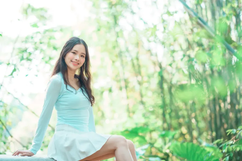 Woman smiling peacefully in natural green forest environment