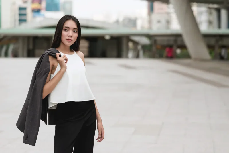 Woman with thoughtful, composed expression in urban environment