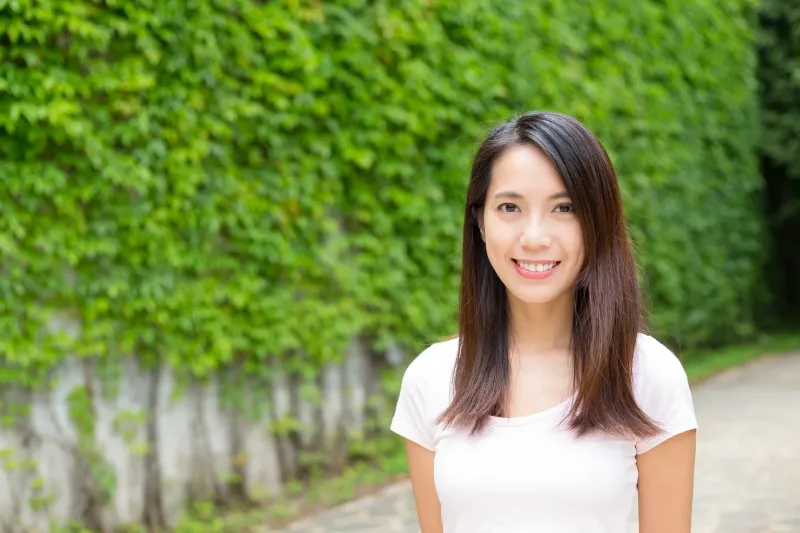 Filipina woman smiling warmly surrounded by natural greenery and nature
