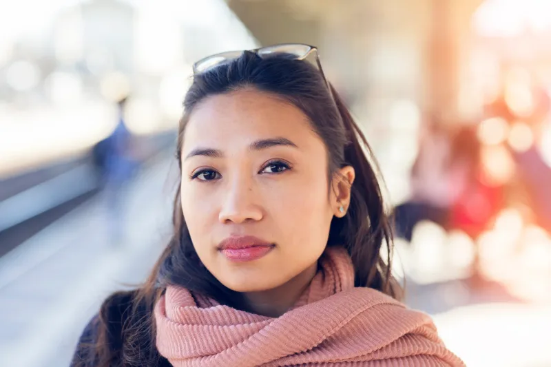 Woman in urban outdoor setting with contemplative expression, representing contemporary Filipino culture